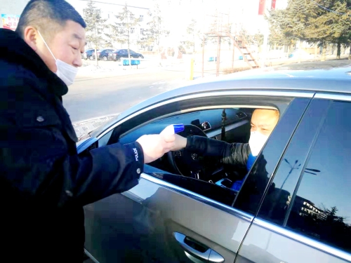 图为东荣二矿守卫科干警严酷检查收支矿车辆，对每名进矿职工都举行体温丈量并挂号。