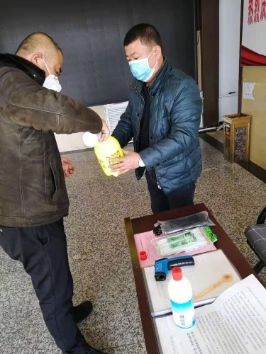 七台河公司春风矿矿党委副书记王占寒在督导检查防疫事情的同时为单位提供测温仪、消毒液、喷壶等防护用品。图为王占寒（左）正与党员对办公场合举行消毒。（于秀娟摄）