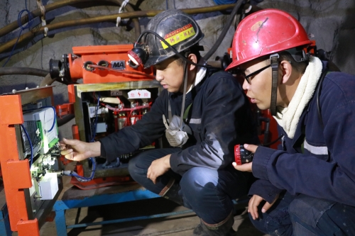 图为事情职员正在井下装置调试煤矿智能供电装备